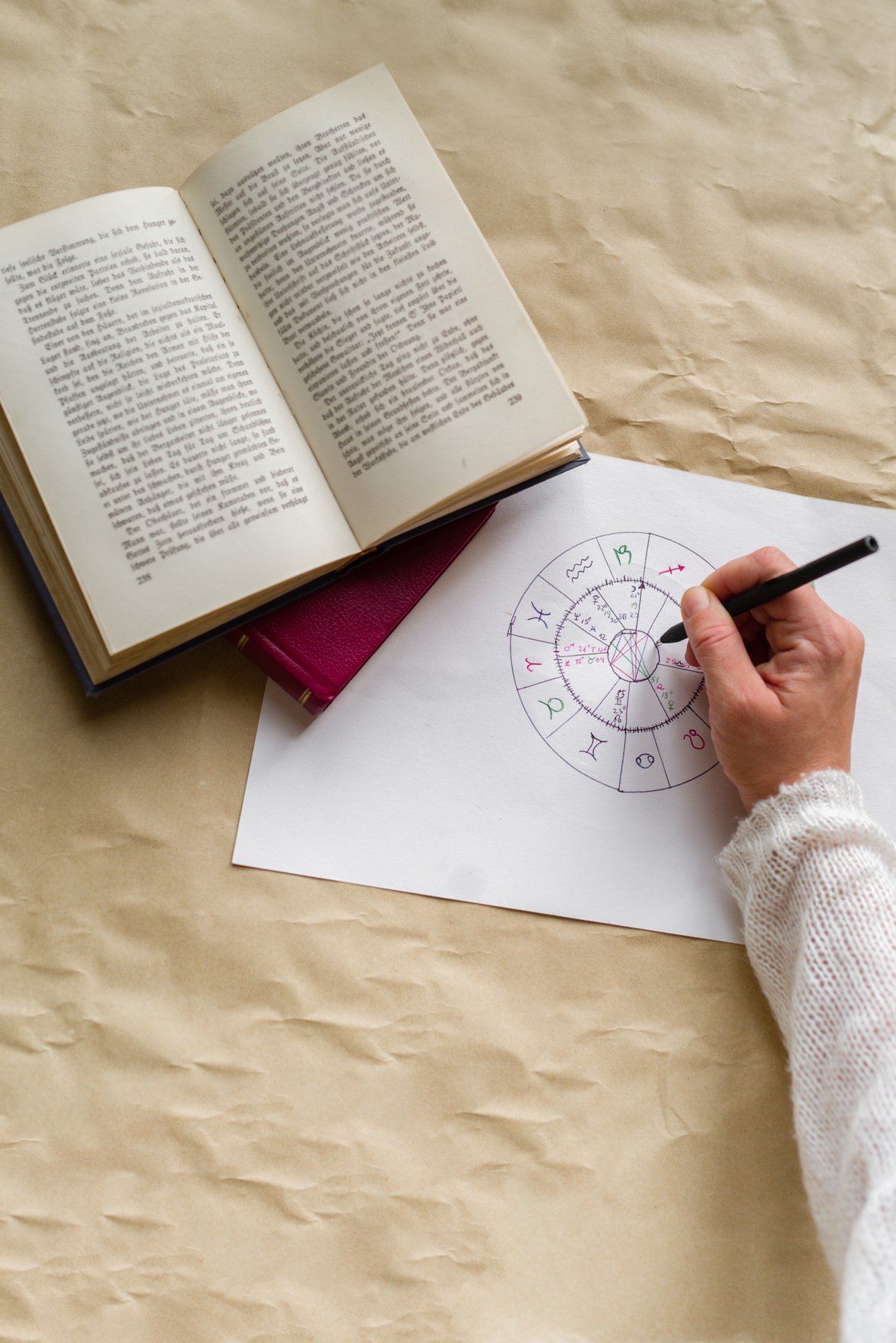 Hands of a woman writing an astrological chart